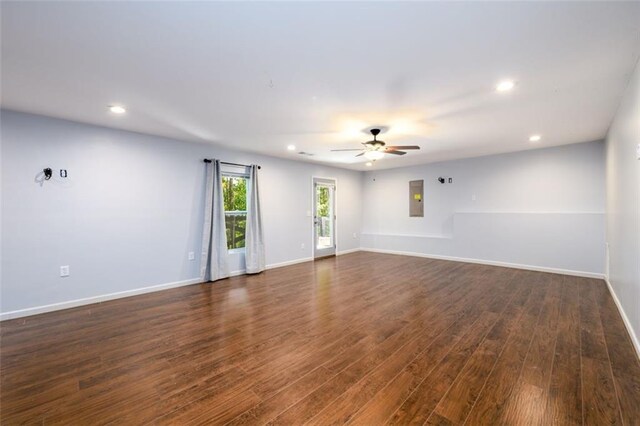 spare room with ceiling fan, electric panel, and dark hardwood / wood-style flooring