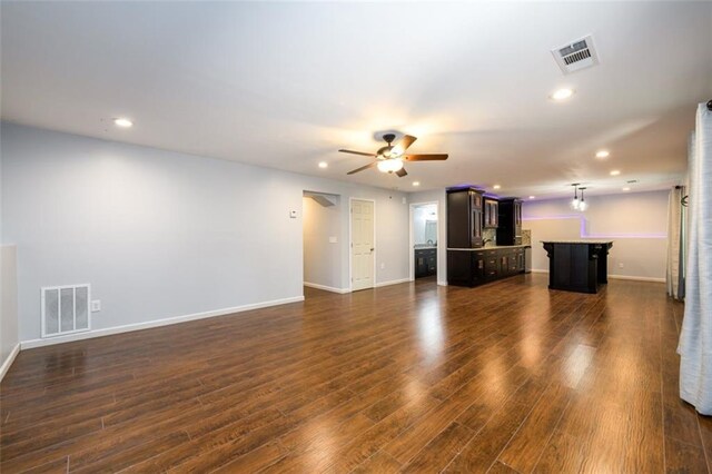 unfurnished living room with ceiling fan and dark wood-type flooring