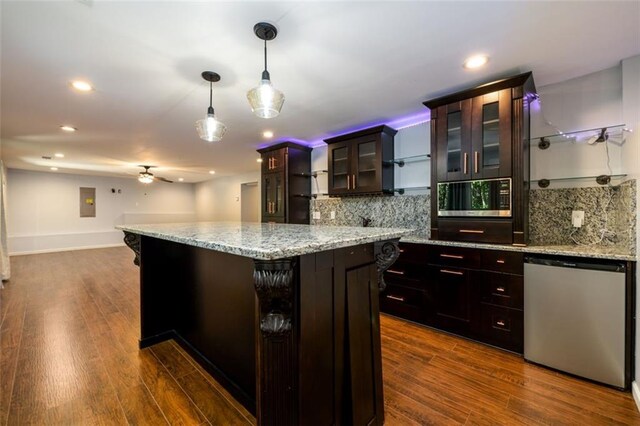 kitchen with dark brown cabinets, a center island, stainless steel appliances, decorative light fixtures, and dark hardwood / wood-style flooring