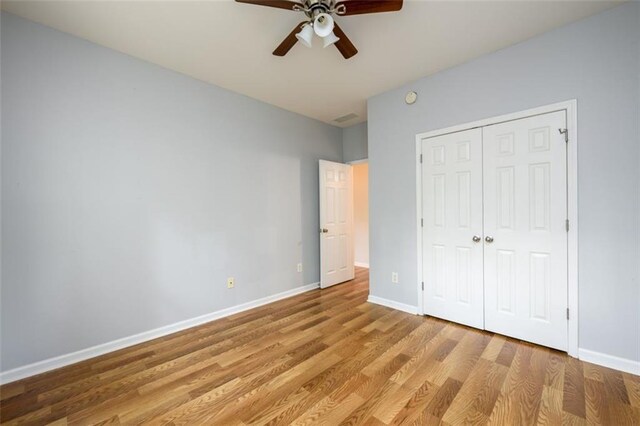 unfurnished bedroom featuring ceiling fan, a closet, and light hardwood / wood-style floors