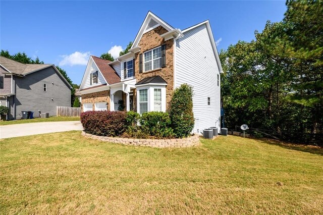 view of front of home with central AC and a front lawn