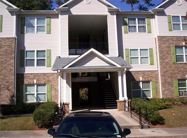 view of front facade featuring stairs and brick siding