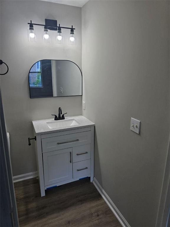 bathroom with wood finished floors, vanity, and baseboards