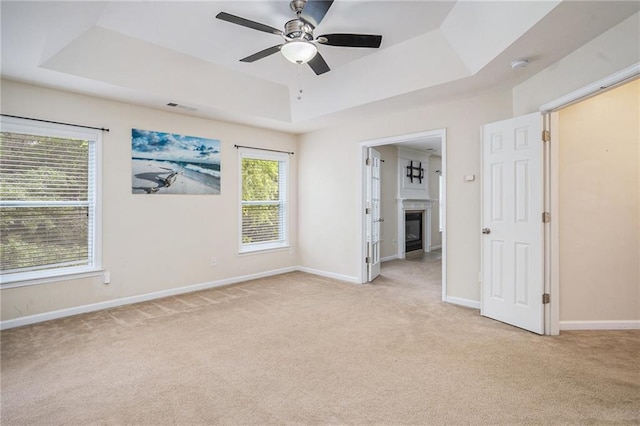 157 Spur Ln, Hiram, GA 30141 - unfurnished bedroom with a raised ceiling, light colored carpet, a glass covered fireplace, and baseboards