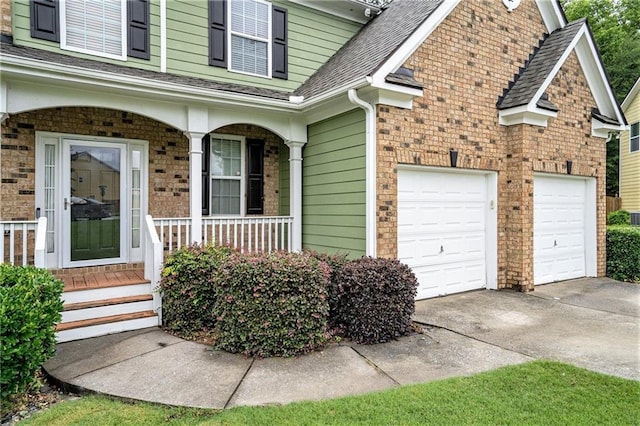 157 Spur Ln, Hiram, GA 30141 - view of exterior entry featuring driveway, covered porch, roof with shingles, brick siding, and a garage