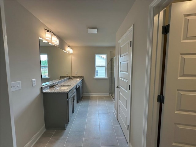 bathroom featuring an enclosed shower, baseboards, double vanity, and a sink