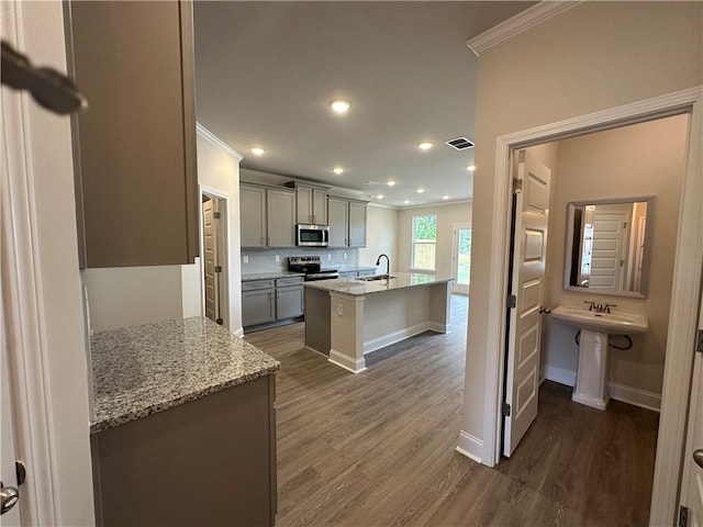 kitchen featuring crown molding, visible vents, dark wood-style floors, a sink, and stainless steel appliances