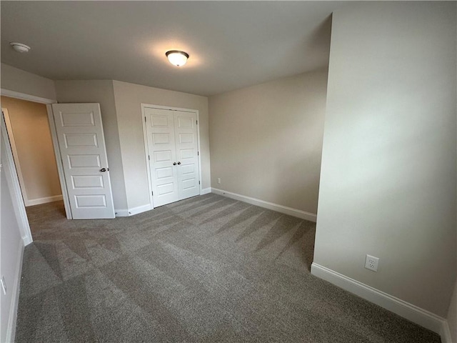 unfurnished bedroom featuring carpet floors, baseboards, and a closet