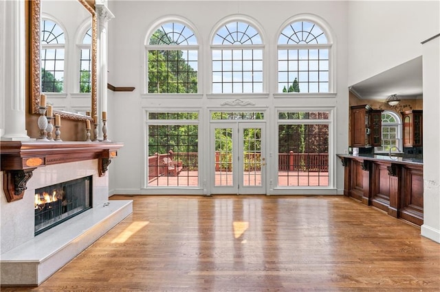 11569 Finley St, Suwanee, GA 30024 - unfurnished living room featuring a high ceiling, a fireplace, wood finished floors, healthy amount of natural light, and a sink