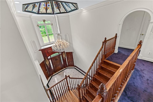 11569 Finley St, Suwanee, GA 30024 - stairway featuring a chandelier, crown molding, carpet flooring, arched walkways, and baseboards