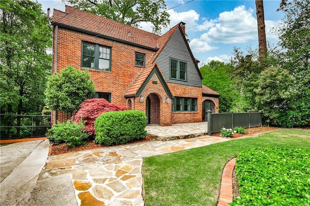 50 Rumson Way NE, Atlanta, GA 30305 - tudor home with brick siding, a front lawn, and fence