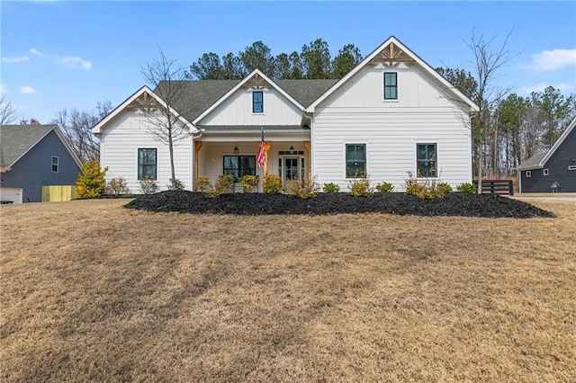 modern inspired farmhouse with a front lawn, a porch, and board and batten siding