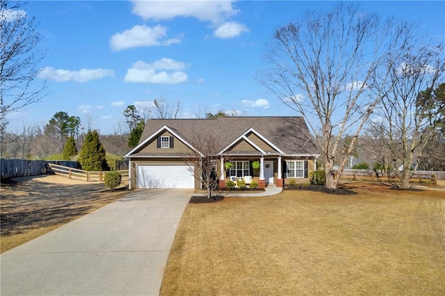 view of front of house with driveway, an attached garage, a front yard, and fence