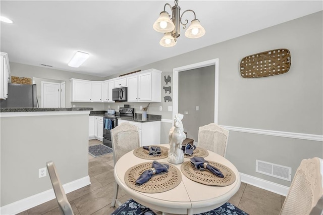 dining space featuring a notable chandelier, baseboards, visible vents, and light tile patterned floors