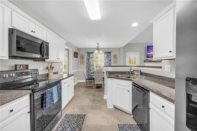 kitchen featuring a notable chandelier, a sink, white cabinetry, stainless steel appliances, and a peninsula