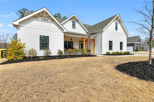 modern farmhouse with a porch, a garage, board and batten siding, and a front lawn