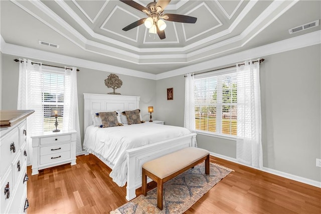 bedroom featuring visible vents, multiple windows, and wood finished floors