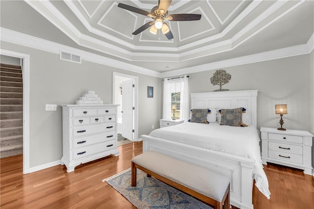 bedroom featuring crown molding, wood finished floors, visible vents, and baseboards