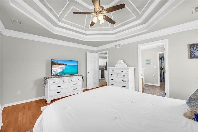 bedroom featuring visible vents, wood finished floors, and ornamental molding