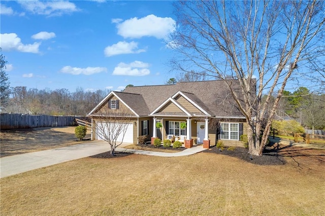 craftsman house with a front yard, concrete driveway, an attached garage, and fence