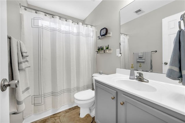 full bath with visible vents, toilet, vanity, and shower / tub combo with curtain