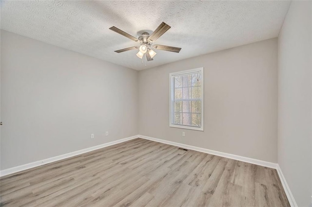 spare room with ceiling fan, a textured ceiling, and light wood-type flooring