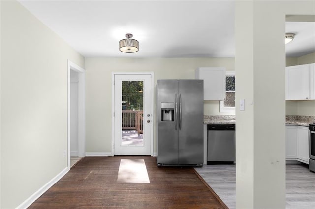 kitchen with baseboards, white cabinetry, stainless steel appliances, and wood finished floors