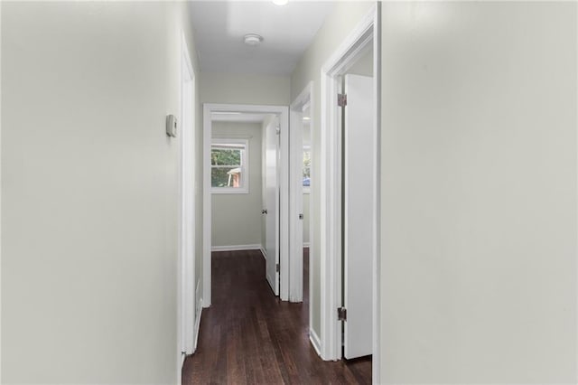 hallway featuring dark wood-style floors and baseboards