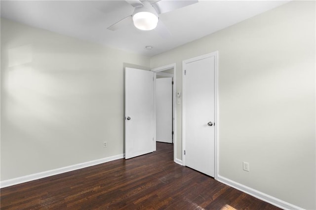 unfurnished bedroom with dark wood-style flooring, ceiling fan, and baseboards