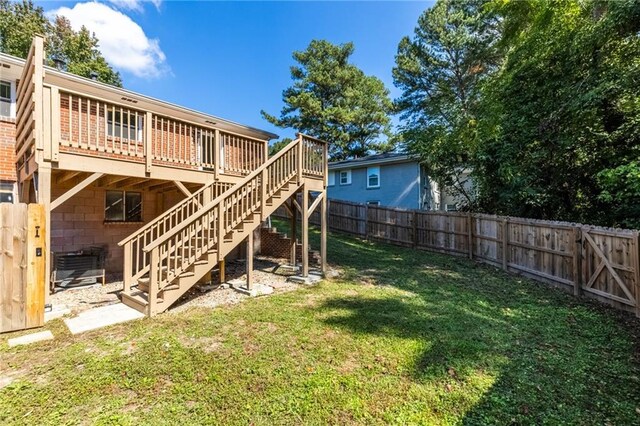 view of yard featuring a fenced backyard, a deck, and stairs