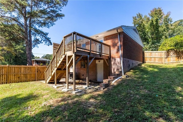 rear view of house with a lawn, a fenced backyard, stairs, a deck, and brick siding