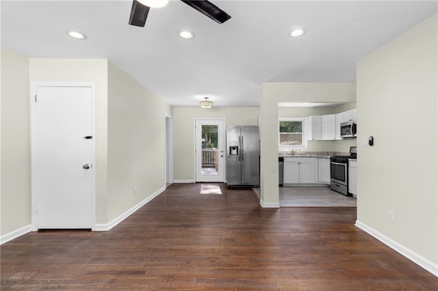 kitchen featuring baseboards, white cabinets, dark wood-style floors, stainless steel appliances, and light countertops