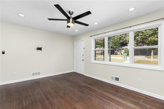 unfurnished room featuring recessed lighting, dark wood finished floors, visible vents, and baseboards