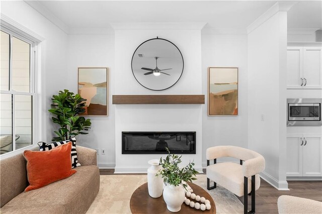 4918 Sudbrook Way Unit 252, Peachtree Corners, GA 30092 - living room featuring a glass covered fireplace, baseboards, a ceiling fan, wood finished floors, and ornamental molding