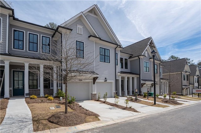 4918 Sudbrook Way Unit 252, Peachtree Corners, GA 30092 - view of front of home with a residential view, concrete driveway, covered porch, a garage, and brick siding