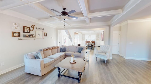 living room featuring coffered ceiling, ceiling fan, light hardwood / wood-style floors, and beamed ceiling