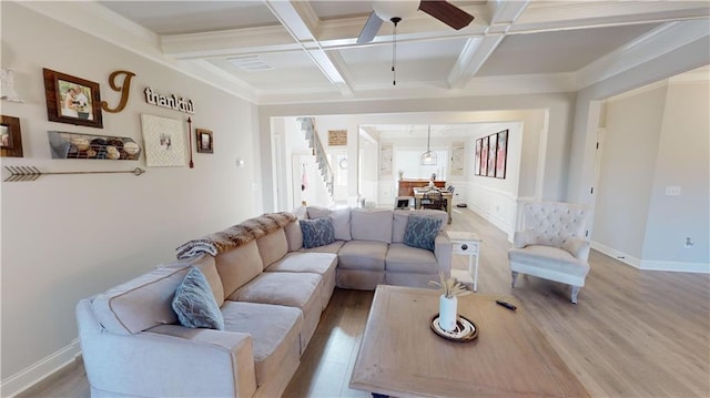 living room featuring beam ceiling, ornamental molding, coffered ceiling, and light hardwood / wood-style floors