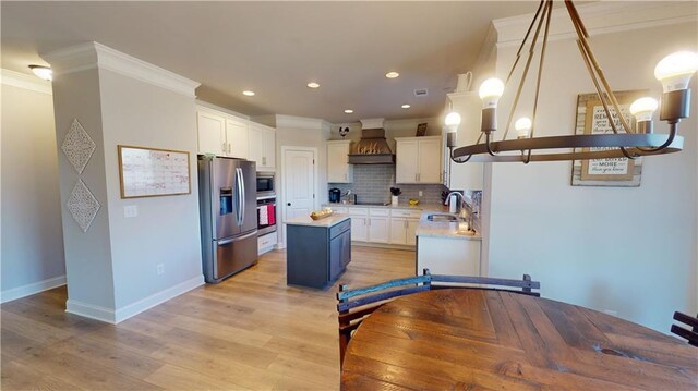 kitchen with stainless steel appliances, a sink, a kitchen island, decorative backsplash, and custom range hood