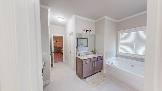 bathroom featuring vanity, baseboards, ornamental molding, a bath, and ensuite bath