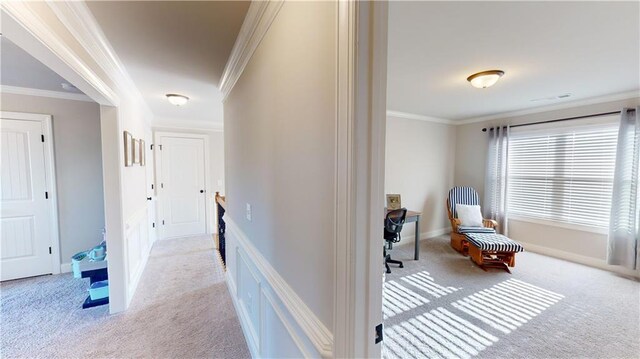 corridor featuring carpet floors, baseboards, visible vents, and crown molding