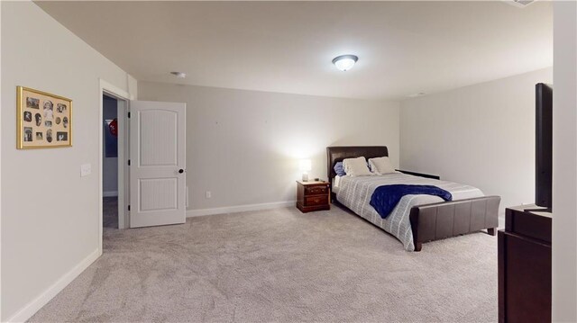 bedroom featuring light carpet and baseboards