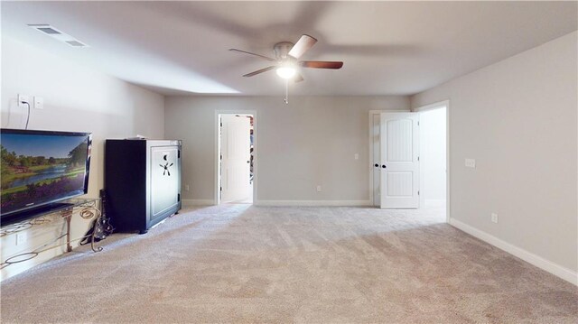 unfurnished living room with carpet floors, visible vents, ceiling fan, and baseboards