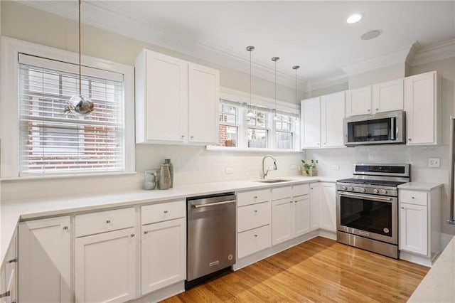 101 Terrace Dr, Atlanta, GA 30305 - kitchen featuring stainless steel appliances, a sink, ornamental molding, tasteful backsplash, and white cabinetry