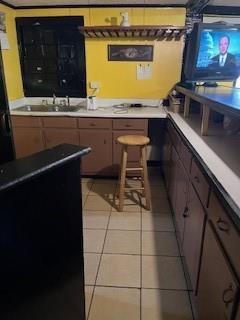 bar with light tile patterned floors and sink