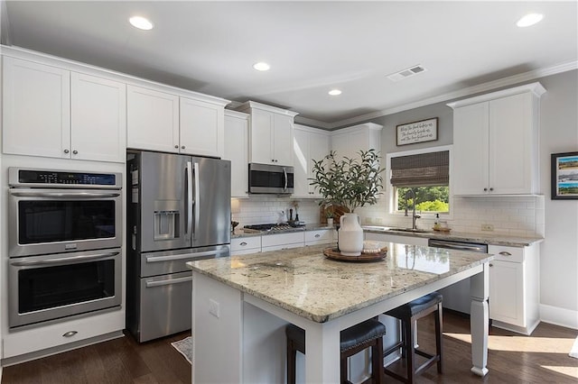 5240 Bristlecone Pine Way, Cumming, GA 30040 - kitchen featuring stainless steel appliances, ornamental molding, white cabinets, light stone counters, and dark wood finished floors