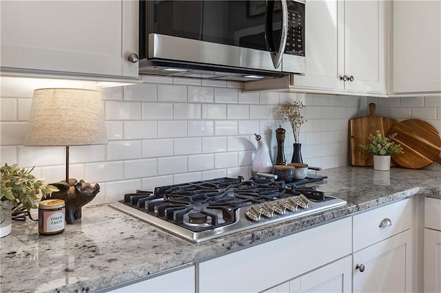 5240 Bristlecone Pine Way, Cumming, GA 30040 - kitchen with appliances with stainless steel finishes, white cabinetry, tasteful backsplash, and light stone countertops