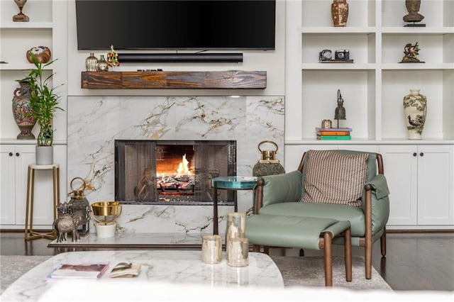 sitting room featuring a fireplace and built in features