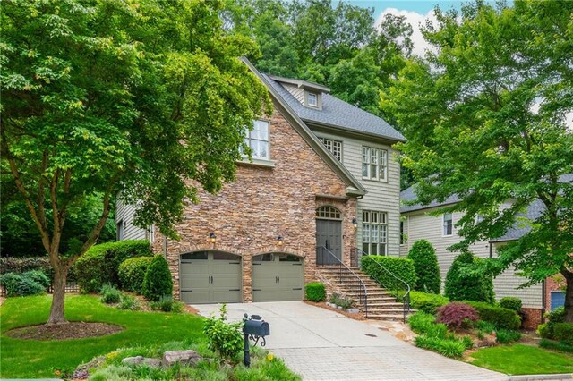 view of front facade with stone siding, a garage, and concrete driveway