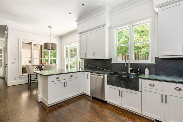kitchen with dishwasher, a peninsula, backsplash, dark countertops, and crown molding