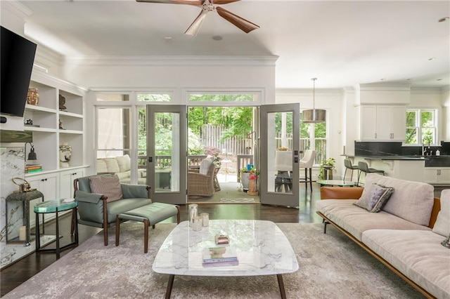 living area with ornamental molding, ceiling fan, dark wood-style floors, and french doors